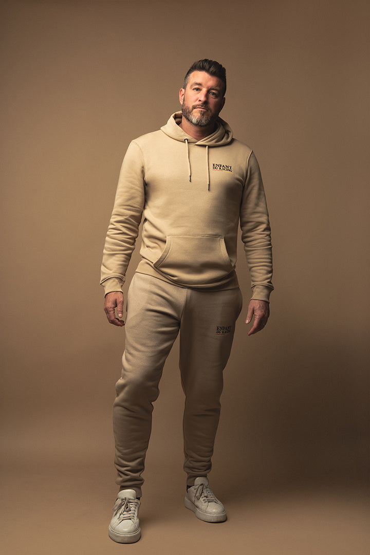 Ce jogging beige avec le logo brodé Enfant du Racing allie douceur et élégance pour un look unique de supporter